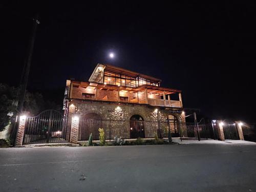 a building with a fence in front of it at night at Lagodekhi Inn in Lagodekhi