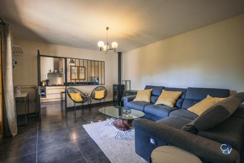 ein Wohnzimmer mit einem blauen Sofa und einem Tisch in der Unterkunft Belle villa provençale - familiale - Grand terrain in Saint-Quentin-la-Poterie