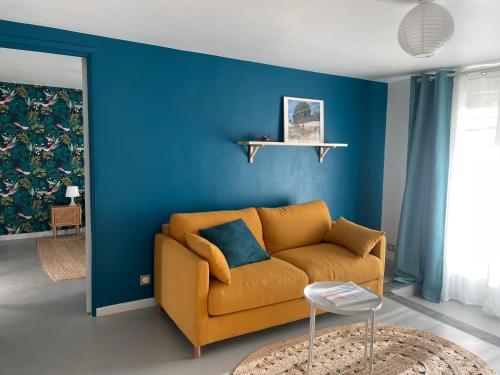 ein Wohnzimmer mit einem Sofa und einer blauen Wand in der Unterkunft Gîte avec terrasse in Saint-Saturnin