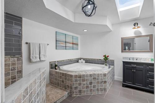 a large bathroom with a large tub and a sink at Luxury Heated Pool Spa Villa with Game Room & More! in Tampa