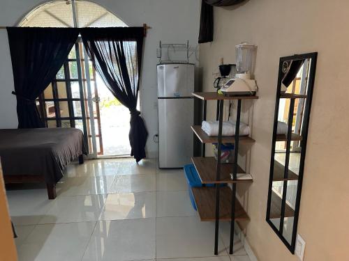 cocina con nevera y habitación con ventana en Bungalow Clavel Barra la Saladita, en La Salada