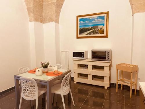 a dining room with a table and a microwave at Dimore di Lecce - La Corte in Lecce