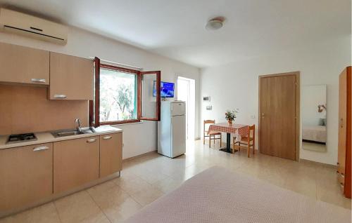 a kitchen with a white refrigerator and a table at Nice Apartment In Vieste With Wifi in Vieste