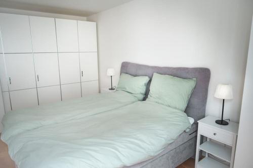 a bedroom with a large white bed with two lamps at Traumwohnung im Kölner Süden in Hürth