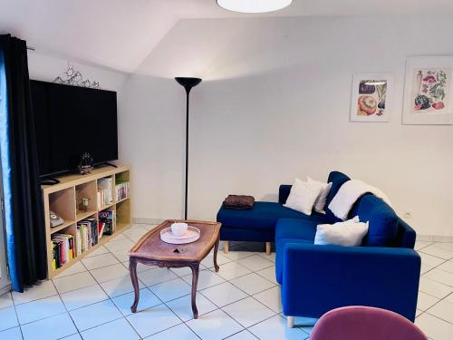 a living room with a blue couch and a table at Chez Armando - Lille Centre in Lille