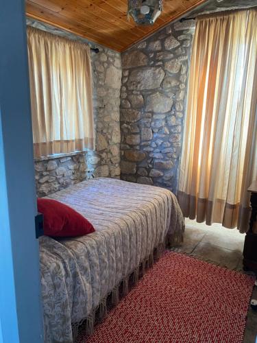 een slaapkamer met een bed met een stenen muur bij Casa do Carqueijo in Vila Praia de Âncora