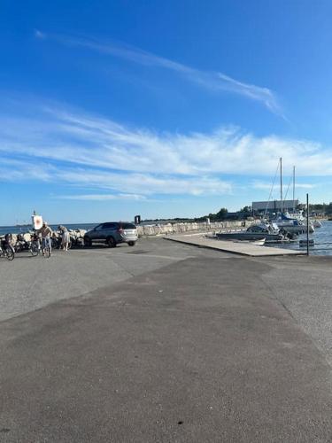 a car parked next to a harbor with boats at Boende på Blekinge Hasslö nära badstrand in Hasslö
