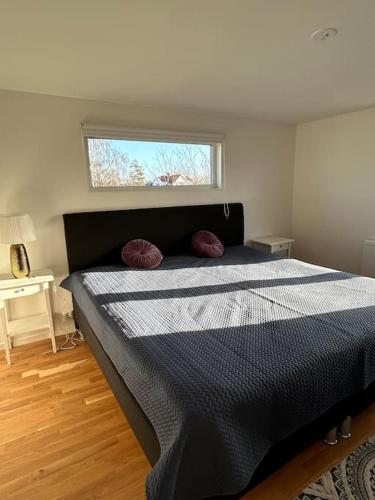 a bedroom with a bed with a black and white comforter at Boende på Blekinge Hasslö nära badstrand in Hasslö
