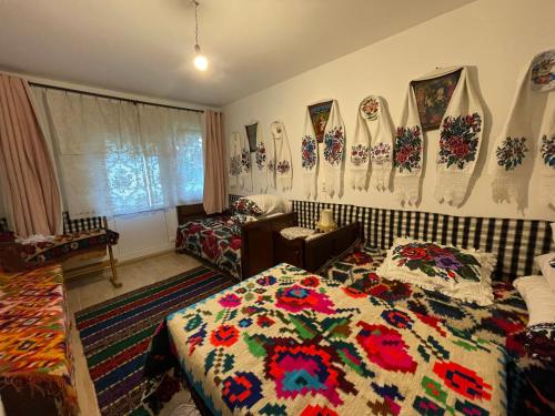 a bedroom with a bed with a colorful quilt on the wall at Casa familiala de vacanta in Bogdan Vodă