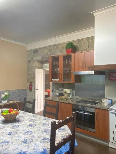 a kitchen with wooden cabinets and a table with a counter top at Casa do Carqueijo in Vila Praia de Âncora