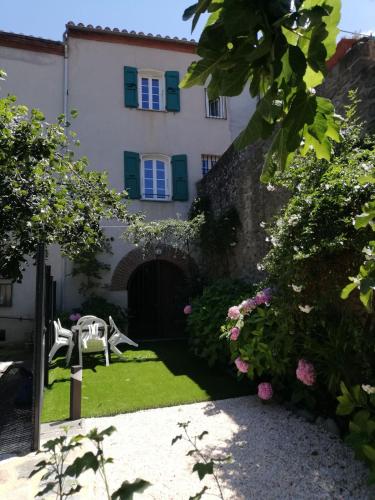 a house with a garden in front of it at Gîte de charme la belle histoire in Prades