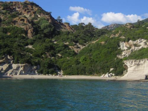 a view of a beach with a mountain at Corte Fiorita Albergo Diffuso in Bosa