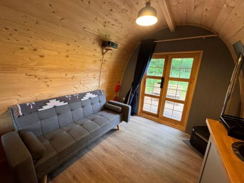 a living room with a couch and a window at Green Oak Nature Retreat in Dunfermline