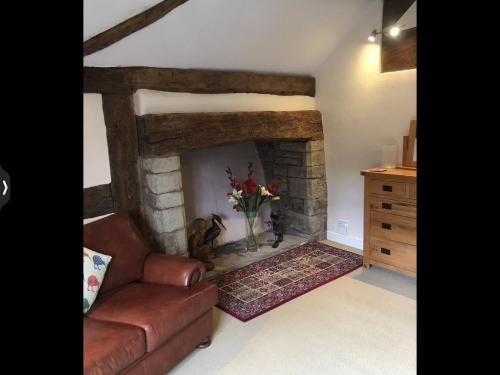 a living room with a couch and a fireplace at The Medlar in Kington