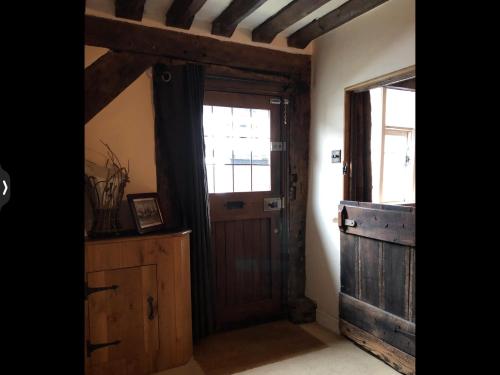 a room with a wooden door and a window at The Medlar in Kington