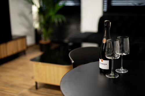 a bottle of wine and two glasses on a table at Hedonia Apartamenty Premium in Opole