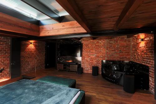 a room with a bed and a brick wall at Hedonia Apartamenty Premium in Opole