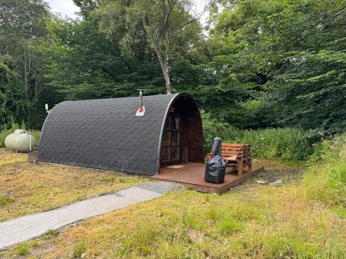 a yurt with a bench and a black roof at Green Oak Nature Retreat in Dunfermline