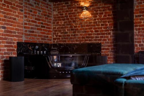 a room with a brick wall and a couch at Hedonia Apartamenty Premium in Opole