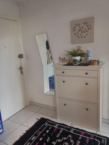 une pièce avec une commode et un tapis à côté d'une porte dans l'établissement mulhouse hyper centre, à Mulhouse