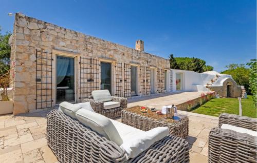an outdoor patio with wicker furniture and a stone building at 2 Bedroom Cozy Home In Ostuni in Ostuni