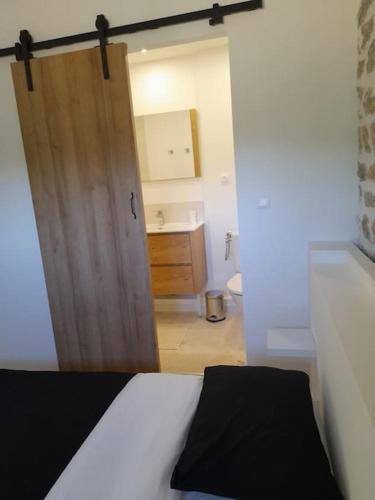 - une chambre avec une porte menant à une salle de bains dans l'établissement L étrier, à Lorgues