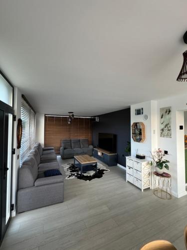 a living room with a couch and a table at Lazăr Home in TÄƒuÅ£ii MÄƒgheruÅŸ