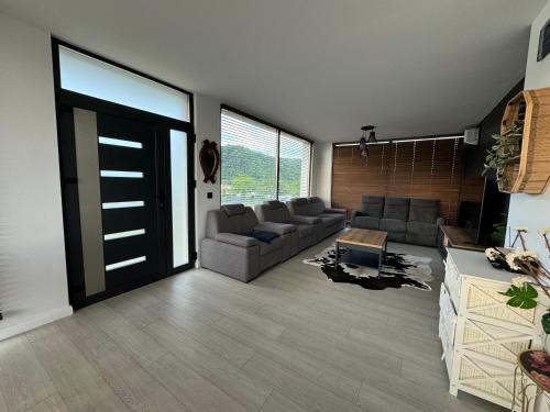 a living room with a couch and a door at Lazăr Home in TÄƒuÅ£ii MÄƒgheruÅŸ