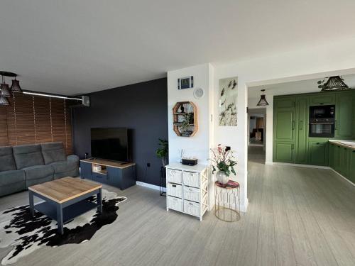 a living room with a couch and a table at Lazăr Home in TÄƒuÅ£ii MÄƒgheruÅŸ
