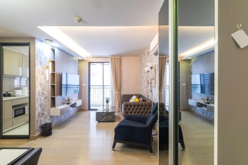 a living room with a couch and a chair at Dazzle Sukhumvit 7 by LeFoyer in Bangkok