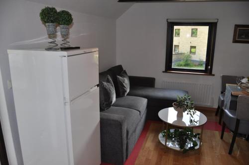 a living room with a couch and a refrigerator at långstorp 200 HÖÖR stugan in Långstorp