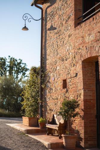 a brick building with potted plants next to a door at Borgo San Vincenzo in Montepulciano