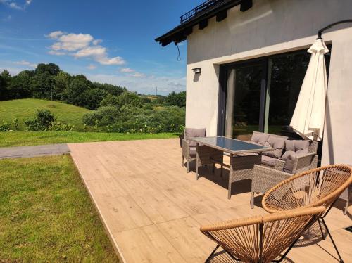 a patio with a table and chairs and a table and chairs at Skośne Domki in Chmielno