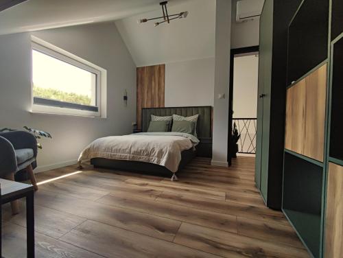 a bedroom with a bed and a window at Skośne Domki in Chmielno