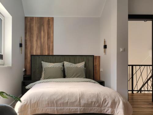 a bedroom with a large bed with a wooden headboard at Skośne Domki in Chmielno