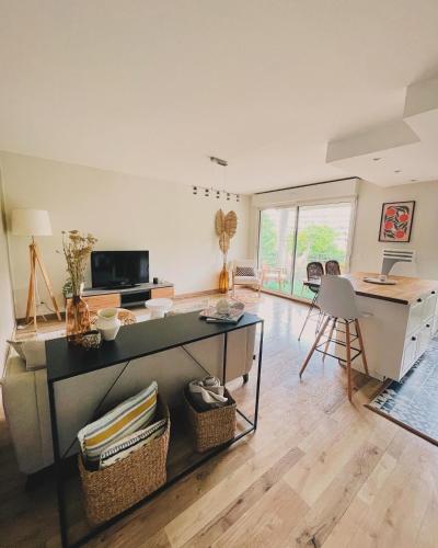 un salon avec une table et un bureau dans l'établissement Appart avec balcon, parking, plein centre ville - MONT DE MARSAN, à Mont-de-Marsan