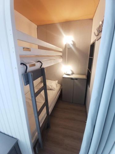 Cette petite chambre comprend des lits superposés et un bureau. dans l'établissement Résidence Diamant - Studio pour 4 Personnes 094, à Aime La Plagne
