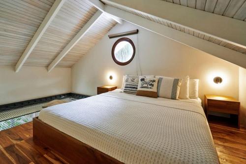 une chambre avec un grand lit dans un grenier dans l'établissement Tucán Studio Malpais, à Malpaís