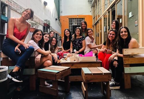 a group of women sitting on tables in a building at Play Hostel Arcos in Buenos Aires