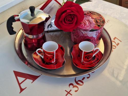 a table with a tray with two cups and roses at Albina apartman in Eger