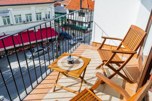 a balcony with two chairs and a table on it at Nani Apartment in Prizren