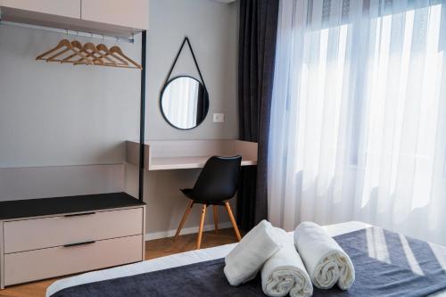 a bedroom with a bed with a mirror and a chair at Nani Apartment in Prizren