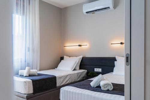 a hotel room with two beds and a window at Nani Apartment in Prizren