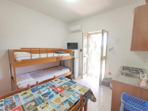 a small room with a table and bunk beds at Villa Scialara in Vieste
