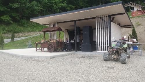 a house with a motorcycle parked in front of it at Cabanele din Valea Ursului in Bîrsana