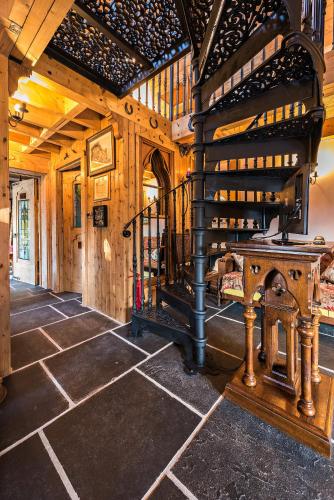 a room with a spiral staircase in a wooden building at Heathfield Hall, Hillsborough - The Coach House in Annahilt
