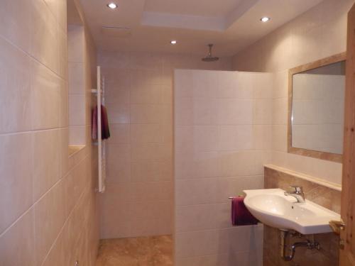 ein Badezimmer mit Waschbecken und Spiegel in der Unterkunft Schloßburg Reiserhof in Zell am Ziller