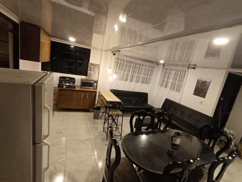 a kitchen and dining room with a table and a refrigerator at Apartamento campestre Montaña Serena in Paipa