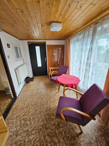a room with purple chairs and a red table at Chalupa Kuks in Kuks