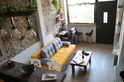 a living room with a yellow couch and tables at Mine in Mytilini